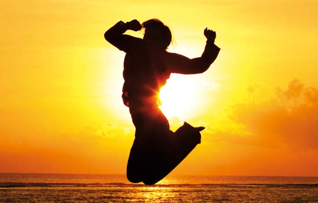 Man jumping against sunrise