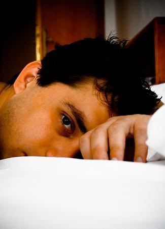 Anxious man lying on bed sleepless