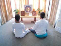 two people meditating in front of light