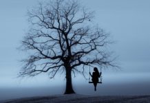 Aloneness: The first lesson of Love Aloneness concept : silhouette of a woman sitting on a swing hanging by a tree