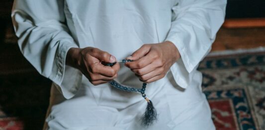 Man practising Islamic chants with beads