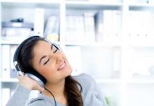 Young, happy woman listening to music on headphones