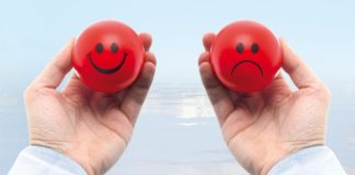Man with one smiling and other sad stress balls