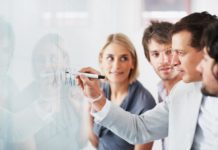 These are the top 20 habits of successful leaders Team looking at their leader while he explaining something on whiteboard
