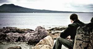 Brooding man gazing at water