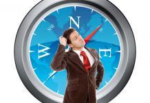 Man thinking standing in front of compass