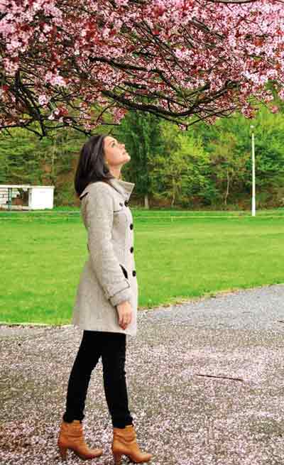 Woman walking at the park gazing the flowers: Mindfulness in daily life
