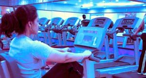 Want to be more satisfied with life? Exercise a little more Young woman exercising in the gym