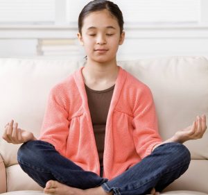 young girl sitting in meditation