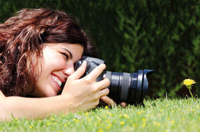 Woman taking a close-up picture of flower