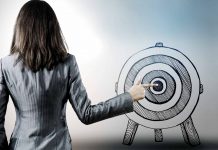 9 hot tips to cultivate a razor sharp focus at work Woman in suit pointing finger on bullseye