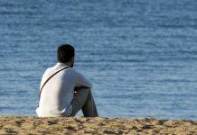 Man alone sitting on the beach