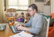 The ups and downs of working from home Man working from home on his laptop with his toddler in the background