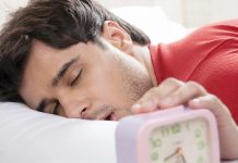 The five golden rules of sleep: Ignore them at your own risk Man sleeping with his hand on alarm clock
