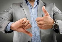 Never Make These Body Language Mistakes at Work Man showing thumbs up and thumbs down; body language