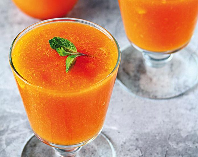 orange drink in glass with mint leaf