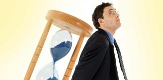 Your attention is your real currency Man lifting old hourglass | Attention is your real currency