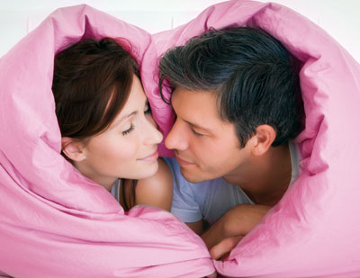Man and woman cuddling in bed