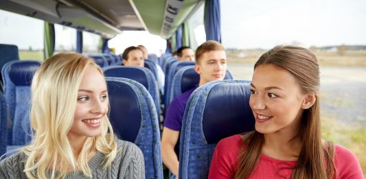 happy young women talking in travel bus