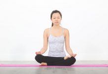 woman sitting on yoga mat in meditation