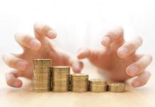 man's hands grabbing coins / concept of greed