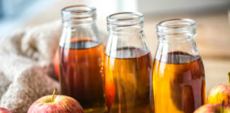 bottles of Apple Cider Vinegar alongside apples