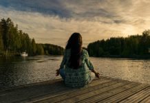 woman facing lake in meditation; vipassana tips