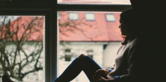 The Paradox of Hope Woman sitting on a window sill with feelings of hopelessness