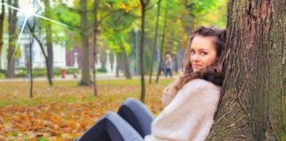 Do relationships increase your chances of being happy? Being happy | Beautiful young woman sitting by herself in the woods