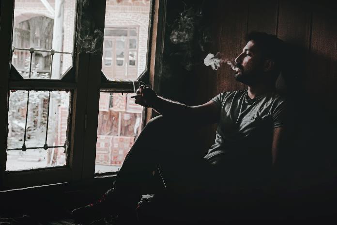 Anxious man smoking alone