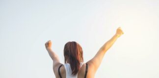5 essential steps to stay motivated Woman with her hands up towards the sky | Concept for staying motivated