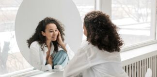 How to Transform Oneself With Mindfulness Concept for transform yourself | Woman smiling at herself in the mirror