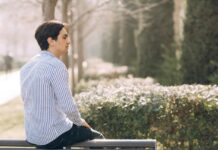 Man sitting on a park bench, seemingly in meditation