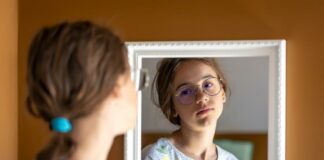 Why You Should Stop Questioning Your Self-Worth Today A teenage girl looking at her reflection in the mirror, doubting her worth