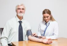 An Occupational Health Nurse checking BP of a senior corporate executive